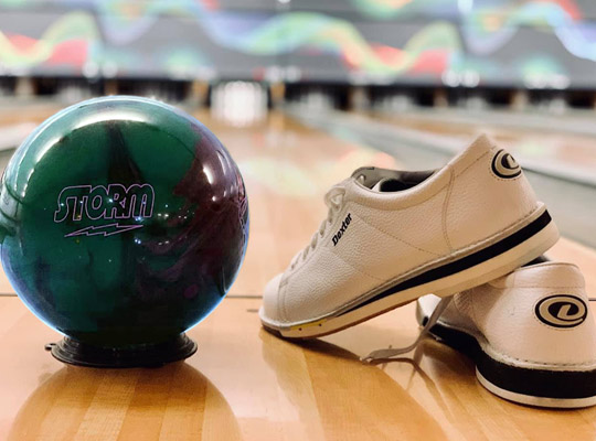 bowling ball and shoes on the lanes